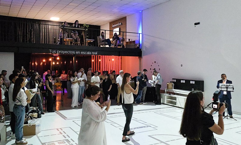 Ganadores del concurso interactuando con sus planos proyectados en el piso a escala 1:1